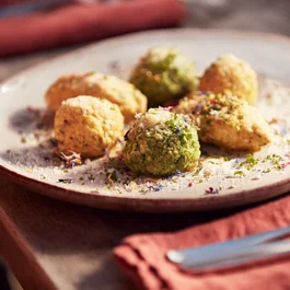 Verschiedene gefüllte Knödel auf einem weißen Teller mit Kräutern dekoriert