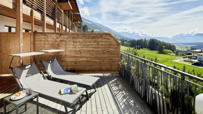 Balkon mit zwei Liegestühlen und Bergblick an einem sonnigen Tag