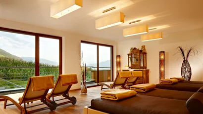 Helles Wellnesszimmer mit Liegestühlen und Aussicht auf die Berge