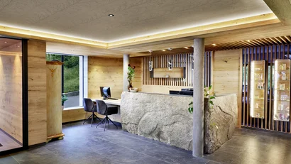 Moderner Empfangsbereich mit Holz und Steintheke in hellem Design