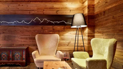 Gemütliche Sitzecke mit Holzvertäfelung, zwei Sesseln und Stehlampe